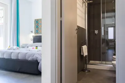 a bedroom with a bed and a glass door to a bathroom at My Way - Suite - Rooms - Palazzo San Matteo in Palermo