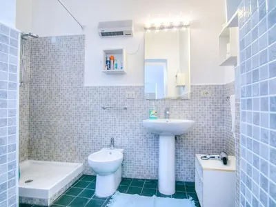 a bathroom with a sink and a toilet and a mirror at Liberty Apartment in Palermo