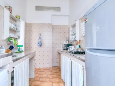 a small kitchen with a refrigerator in a room at Liberty Apartment in Palermo