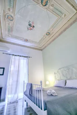 a bedroom with a ceiling with a bed and a crib at Liberty Apartment in Palermo