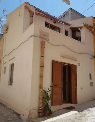 a white building with a chimney and a door at La Perla Bianca in Castellammare del Golfo