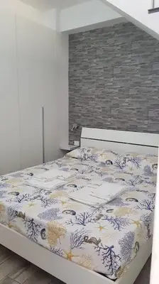 a bedroom with a bed with a floral bedspread at La Perla Bianca in Castellammare del Golfo