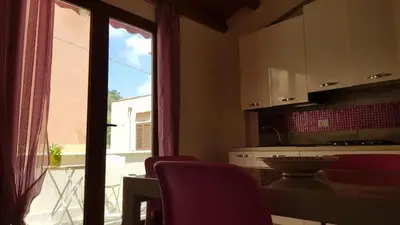 a kitchen with a table and chairs and a window at La Perla Bianca in Castellammare del Golfo