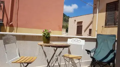 a table and two chairs on a balcony at La Perla Bianca in Castellammare del Golfo