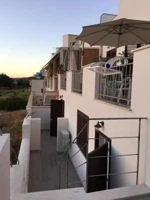 a balcony with an umbrella on the side of a building at Un mare di Blu - Casa Cobalto in Macari
