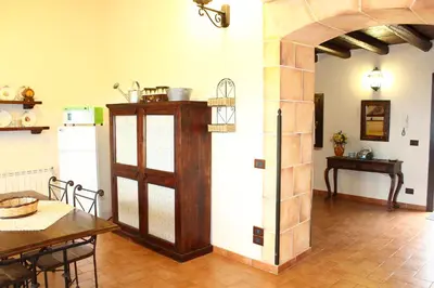 a kitchen and dining room with a table and a door at Casale Maddalena in Carini