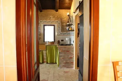 a hallway with a kitchen with a table in it at Casale Maddalena in Carini