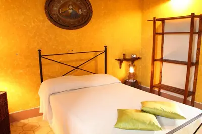 a bedroom with a white bed with two pillows on it at Casale Maddalena in Carini