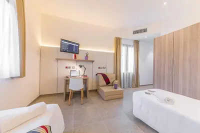 a hotel room with a bed and a desk with a computer at Camplus Palermo Normanni - in Palermo