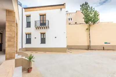 an empty parking lot in front of a white building at Camplus Palermo Normanni - in Palermo