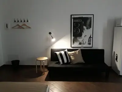 a living room with a black couch and a table at Pirtuso Del Porto in Palermo