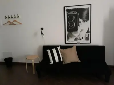 a black couch in a room with a picture of a speaker at Pirtuso Del Porto in Palermo