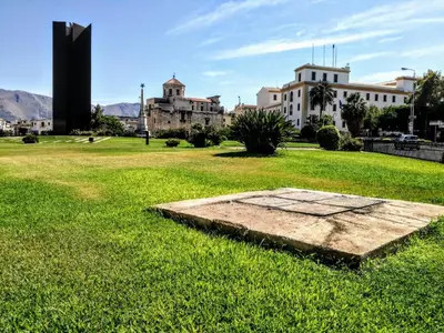 a stone slab in the grass with buildings in the background at Pirtuso Del Porto in Palermo