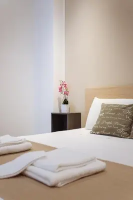 a white bed with two folded towels on it at Politeama Luxury Suites in Palermo