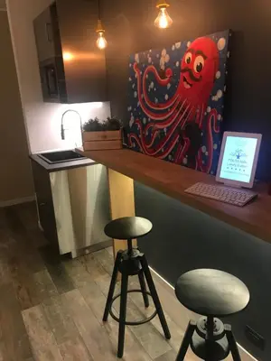 a kitchen with a counter with a laptop and two stools at Politeama Luxury Suites in Palermo