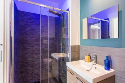 a bathroom with a sink and a glass shower at Politeama Luxury Suites in Palermo
