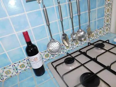 a bottle of wine sitting next to a stove at Residenza del Mare & SPA in San Vito lo Capo