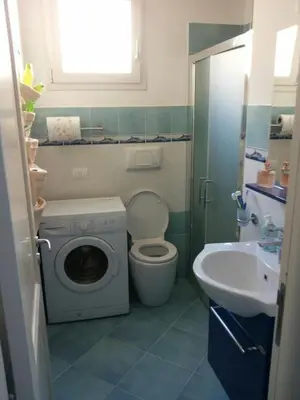 a bathroom with a washing machine and a sink at Residenza del Mare & SPA in San Vito lo Capo