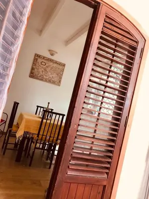 a large wooden door in a room with a table at House in Mondello in Mondello