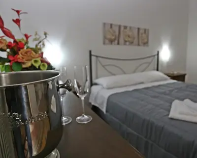 a bedroom with a bed and a table with a pot and wine glasses at Rest and Go in Palermo