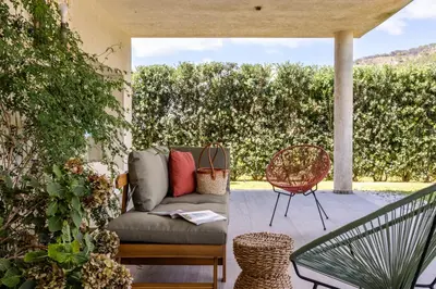 a patio with a couch and a chair at Villa Bonifato vista sulle campagne e sul mare siciliano COZY HOUSE ITALY in Alcamo