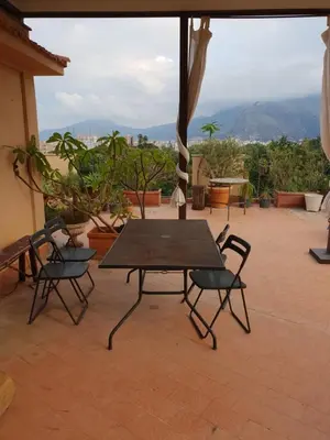a table and chairs on a patio with a view at Panoramica Blu in Palermo