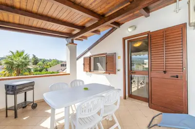 a patio with a table and chairs and a window at Arvilla's Houses in Campofelice di Roccella