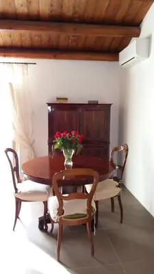 a dining room table with chairs and a vase of flowers at Appartamento Alloro 2 in Palermo