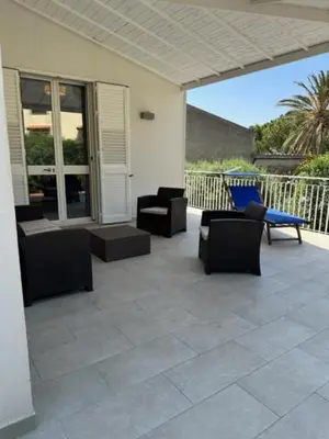 a patio with chairs and chairs on a house at casa verdemare in Cefalù