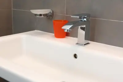 a bathroom sink with a faucet and a red cup at casa verdemare in Cefalù