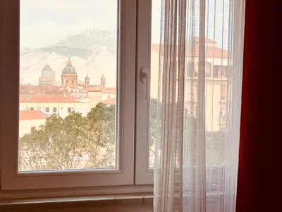 a bedroom with a bed with orange walls and a window at LeAlbe di Sicilia in Palermo