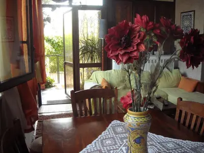 a vase with red flowers sitting on a table at Apartment Ro a Mondello in Mondello