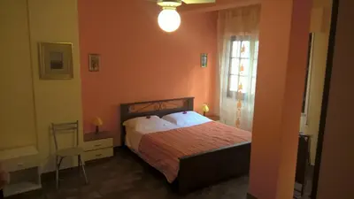 a bedroom with a bed and a window and a chair at Villa Ania in Mondello