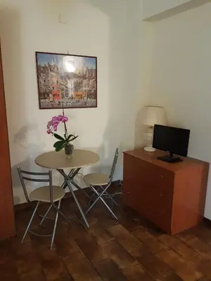 a room with a table and a desk with a television at Villa Ania in Mondello