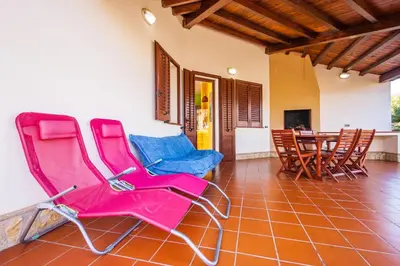 a room with pink chairs and a table and chairs at Sole Mare Deluxe in Campofelice di Roccella
