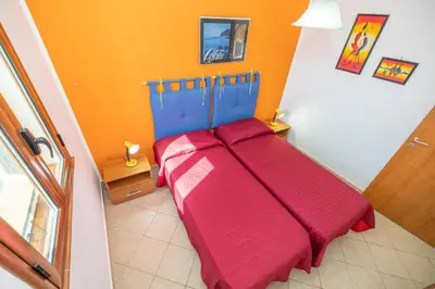 a bedroom with a bed with red blankets on it at Sole Mare Deluxe in Campofelice di Roccella