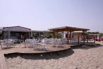 a group of chairs and tables on the beach at Sole Mare Deluxe in Campofelice di Roccella