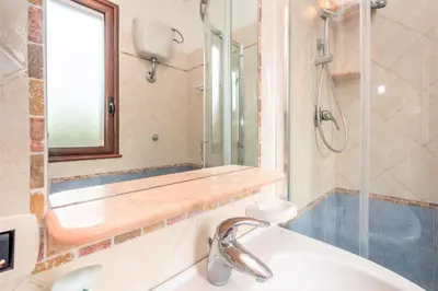 a bathroom with a sink and a shower with a mirror at Sole Mare Deluxe in Campofelice di Roccella