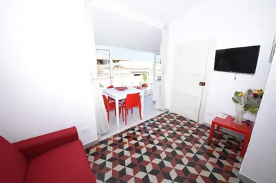 a living room with a red couch and a table at Terrazza in Palazzo Taormina in Castellammare del Golfo
