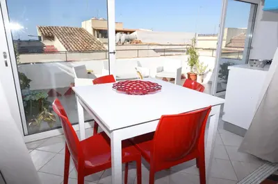 a dining room with a white table and red chairs at Terrazza in Palazzo Taormina in Castellammare del Golfo