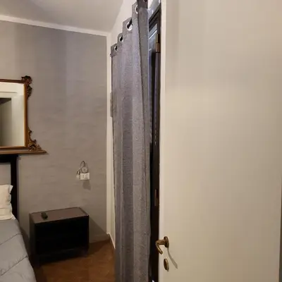a bedroom with a bed and a door with a curtain at 