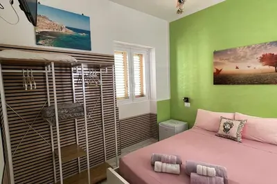a bedroom with a pink bed and green walls at 