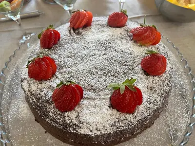 a chocolate cake with powdered sugar and strawberries on it at B&B Mondello Design in Mondello