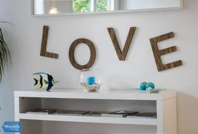 a white shelf with a bowl of fish and a mirror at B&B Mondello Design in Mondello