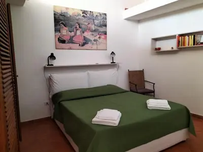 a bedroom with a green bed with two towels on it at Green Space Apartment in Mondello