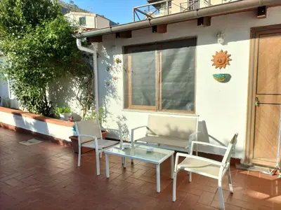 a patio with two chairs and a glass table at Green Space Apartment in Mondello