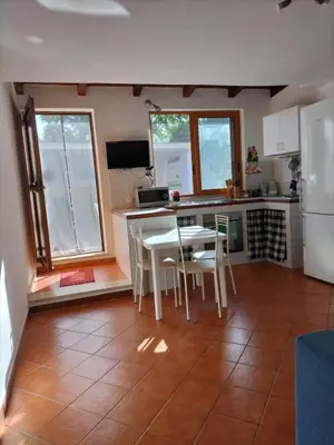 a kitchen with a white table and a white refrigerator at Green Space Apartment in Mondello