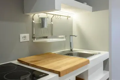 a kitchen with a sink and a wooden cutting board at Palermo ai Leoni in Palermo