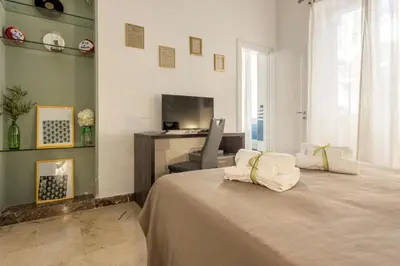 a bedroom with a bed and a desk in a room at MassimoCentro Rooms in Palermo