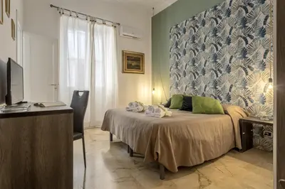 a hallway with stairs and paintings on the walls at MassimoCentro Rooms in Palermo